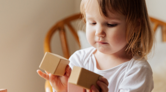 Afbeelding van kindje wat met blokken aan het spelen is